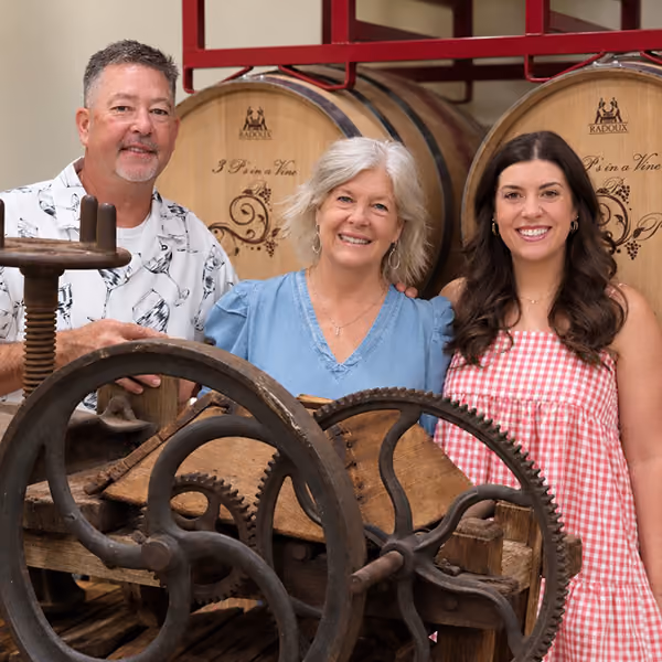 The 3 owners of 3 P's smiling at their wine press